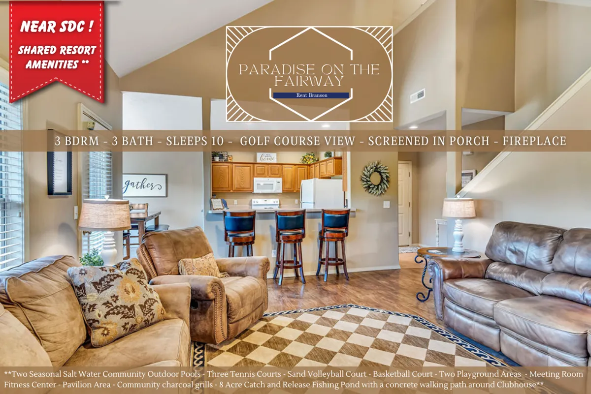 This image captures a spacious, comfortable seating area with a view of the kitchen featuring bar stools, and large windows offering a glimpse of the golf course outside. Decorative wall art adds warmth, and the inviting layout highlights both the living and kitchen spaces.